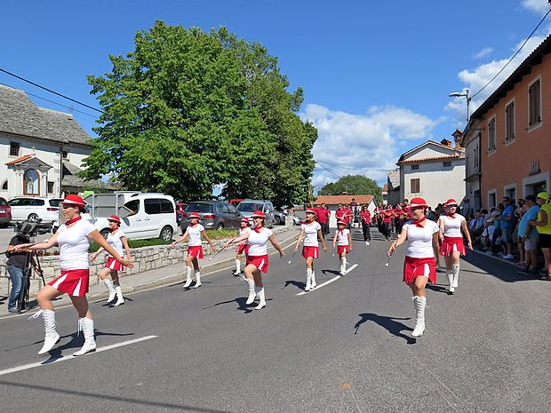 Mažoretke iz Povirja so skupaj s Kraško pihalno godbo (v
ozadju) odprle povorko ob Prazniku terana in pršuta.