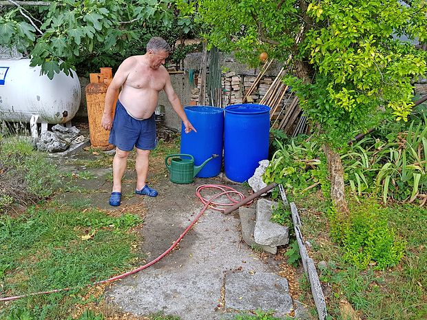 Domačin Slavko Dobrin kaže, kje na vrtu ima nameščeno
greznico.