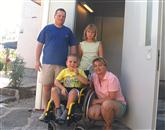 Sedemletni Žiga Krebelj z družino ob nepogrešljivem dvigalu, za katerega so na Bistriškem in drugod v okviru humanitarne akcije zbrali denar   Foto: Tomo Šajn