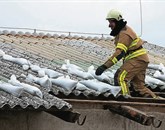 Veter je odkrival strehe, gasilci so strešne kritine obtežili z vrečami peska. Fotografija je iz arhiva.  Foto: Leo Caharija