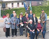 Dvanajst Sušačank in Sušačanov, ki so doživeli tragične dogodke leta 1944, pred spomenikom žrtvam vojne  Foto: Tomo Šajn