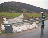 Poplave podtalne vode (na fotografiji zadrževanje hudournika s protipoplavnimi vrečami na Baču), ki na Bistriškem še zdaleč niso poniknile, bodo občinski proračun tedensko oklestile za več kot 25.000 evrov. Foto: Lori Ferko