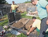 Preden je naročil premik betonskega okvirja in spominske plošče na grobu Bizjakovih, se je izvršitelj Tadej Poljak (desno) s pomočjo komunalnih delavcev prepričal, da so krste dovolj oddaljene od sosednjega groba Foto: Igor Mali/Slovenske Novice